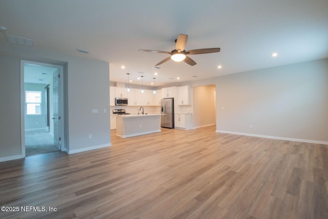 75309 White Rabbit Ave, Yulee, FL 32097 - unfurnished living room with ceiling fan, light wood-style floors, and recessed lighting