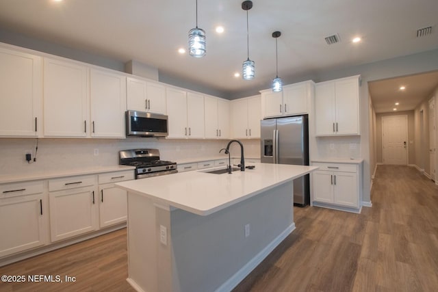 75309 White Rabbit Ave, Yulee, FL 32097 - kitchen with appliances with stainless steel finishes, dark wood-style floors, tasteful backsplash, recessed lighting, and a center island with sink