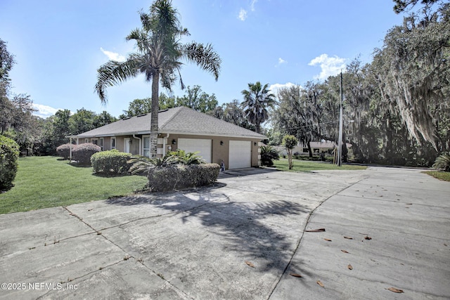 view of front of property with a front lawn, stucco siding, an attached garage, and concrete driveway