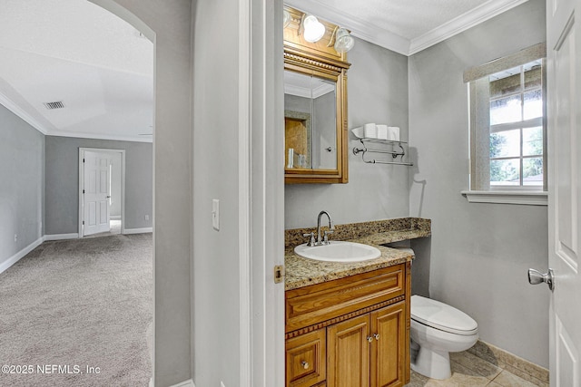 bathroom featuring vanity, ornamental molding, visible vents, toilet, and baseboards
