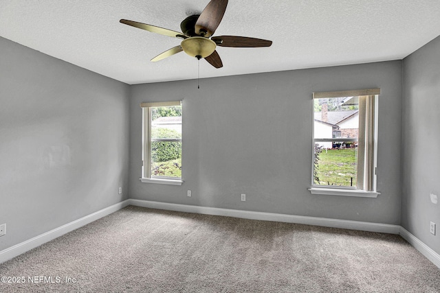 carpeted empty room featuring a textured ceiling, baseboards, and a ceiling fan