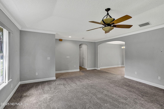 spare room with plenty of natural light, arched walkways, visible vents, and carpet floors