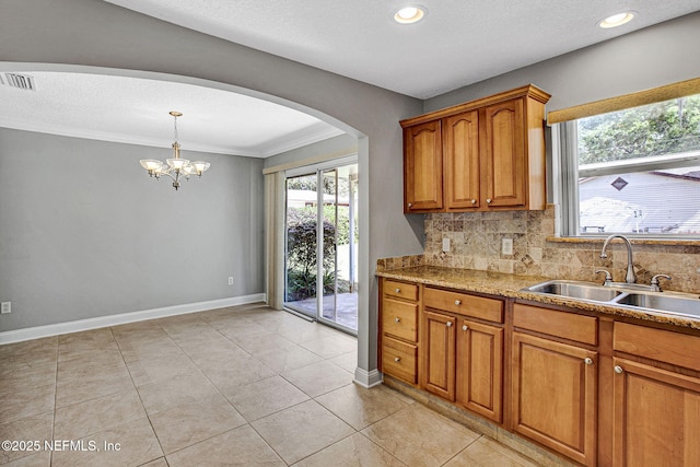 kitchen featuring arched walkways, a sink, visible vents, and a wealth of natural light