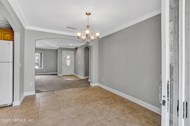 foyer entrance featuring crown molding, light tile patterned floors, arched walkways, visible vents, and a notable chandelier