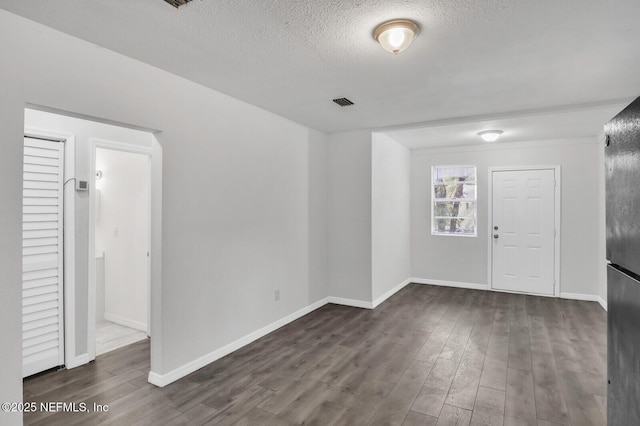 1354 Crestwood St, Jacksonville, FL 32208 - unfurnished room with a textured ceiling, dark wood-style flooring, baseboards, and visible vents