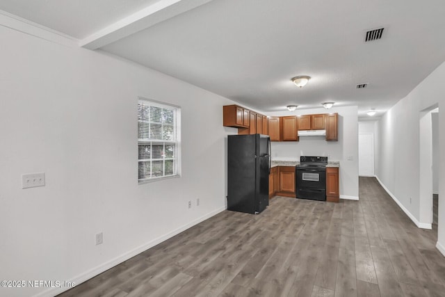 1354 Crestwood St, Jacksonville, FL 32208 - kitchen featuring black appliances, under cabinet range hood, wood finished floors, light countertops, and baseboards