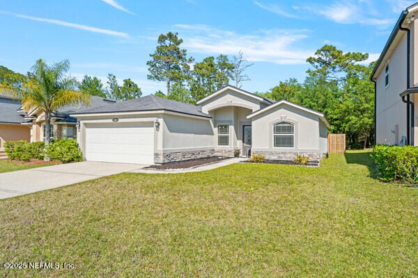 116 Timberwood Dr, Saint Augustine, FL 32084 - ranch-style home with stucco siding, an attached garage, a front lawn, and driveway