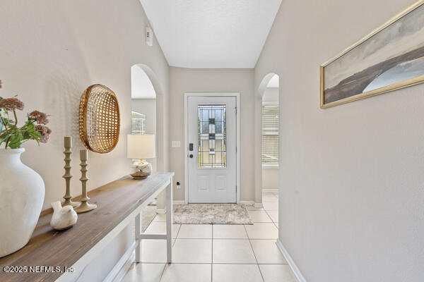 116 Timberwood Dr, Saint Augustine, FL 32084 - foyer entrance with arched walkways, light tile patterned floors, and baseboards