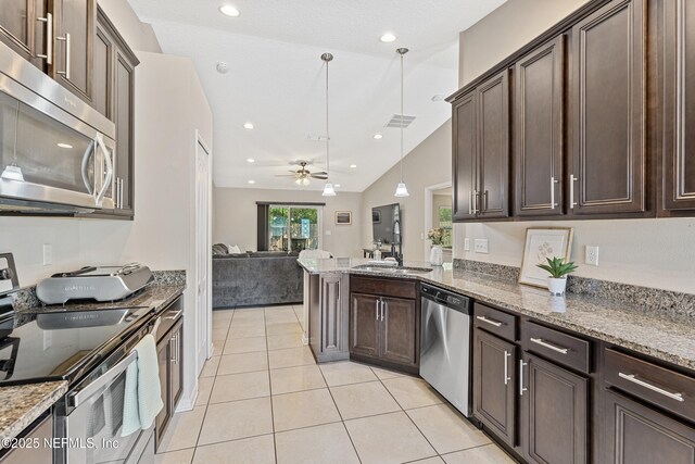 116 Timberwood Dr, Saint Augustine, FL 32084 - kitchen with stainless steel appliances, dark brown cabinets, light tile patterned floors, a sink, and vaulted ceiling