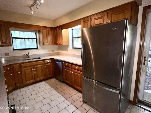 510 W Hillsborough Ave, Florahome, FL 32140 - kitchen featuring a sink, brown cabinets, freestanding refrigerator, and dishwashing machine