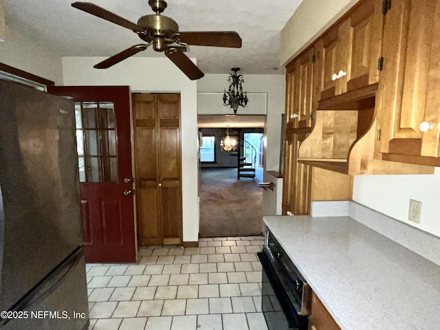 510 W Hillsborough Ave, Florahome, FL 32140 - kitchen with light countertops, freestanding refrigerator, and ceiling fan with notable chandelier