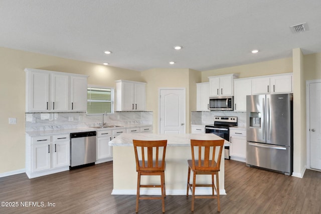 2351 Oak Stream Dr, Green Cove Springs, FL 32043 - kitchen featuring appliances with stainless steel finishes, a sink, white cabinetry, and a kitchen island