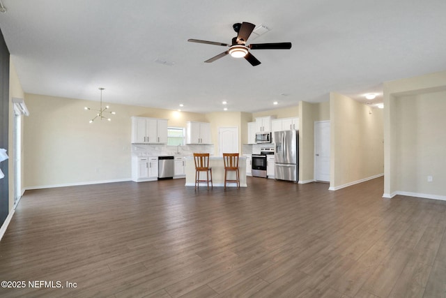 2351 Oak Stream Dr, Green Cove Springs, FL 32043 - unfurnished living room featuring recessed lighting, dark wood-style floors, ceiling fan with notable chandelier, and baseboards