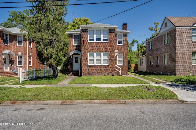 2649 Dellwood Ave, Jacksonville, FL 32204 - view of property featuring a front yard, brick siding, entry steps, and a chimney