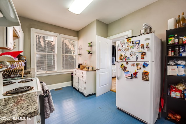 2649 Dellwood Ave, Jacksonville, FL 32204 - kitchen with freestanding refrigerator, dark wood-type flooring, white cabinetry, range with electric cooktop, and baseboards