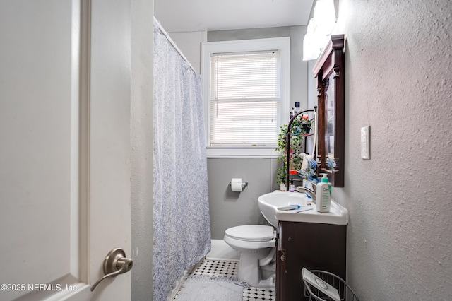 2649 Dellwood Ave, Jacksonville, FL 32204 - full bath featuring a shower with shower curtain, vanity, a textured wall, tile patterned flooring, and toilet