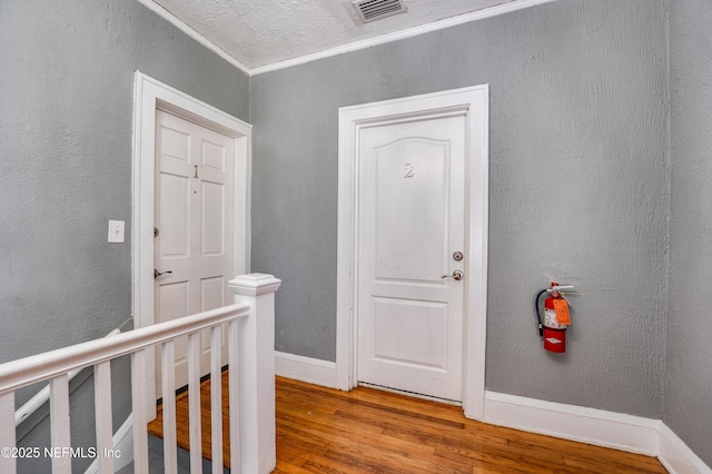2649 Dellwood Ave, Jacksonville, FL 32204 - corridor featuring visible vents, a textured wall, and wood finished floors