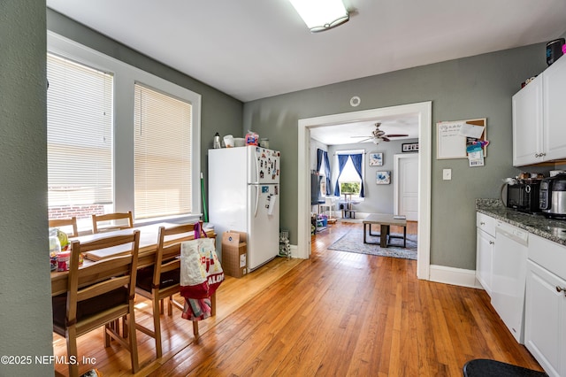 2649 Dellwood Ave, Jacksonville, FL 32204 - kitchen with baseboards, ceiling fan, white appliances, white cabinetry, and light wood-style flooring