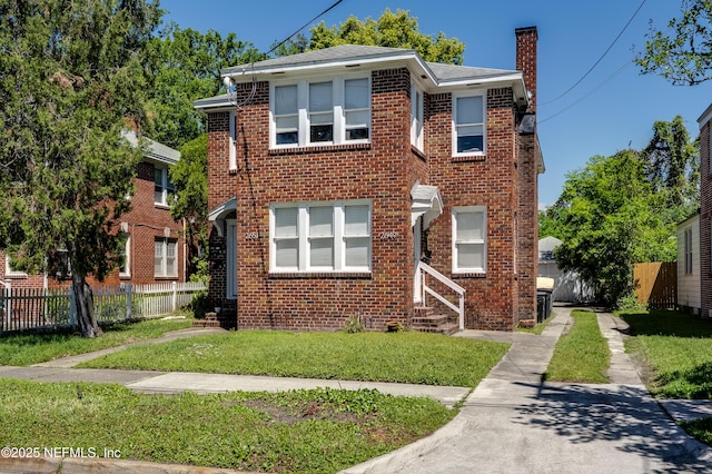 2649 Dellwood Ave, Jacksonville, FL 32204 - view of front of house with entry steps, a chimney, fence, brick siding, and a front lawn