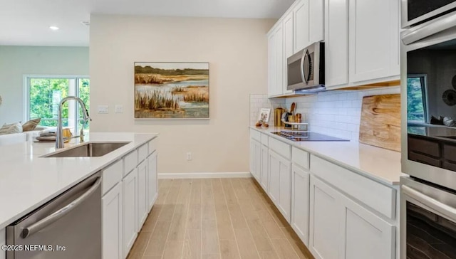 2781 Seasons Rd, Green Cove Springs, FL 32043 - kitchen with white cabinets, stainless steel appliances, light countertops, a sink, and decorative backsplash