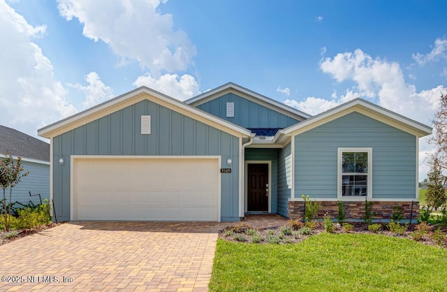 2781 Seasons Rd, Green Cove Springs, FL 32043 - view of front of home with board and batten siding, a garage, a front yard, and decorative driveway
