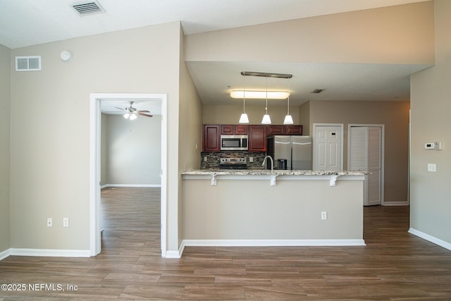 8235 Lobster Bay Ct Unit 305, Jacksonville, FL 32256 - kitchen featuring a peninsula, visible vents, a kitchen breakfast bar, and appliances with stainless steel finishes
