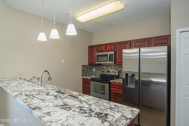 8235 Lobster Bay Ct Unit 305, Jacksonville, FL 32256 - kitchen featuring a peninsula, decorative backsplash, pendant lighting, appliances with stainless steel finishes, and reddish brown cabinets