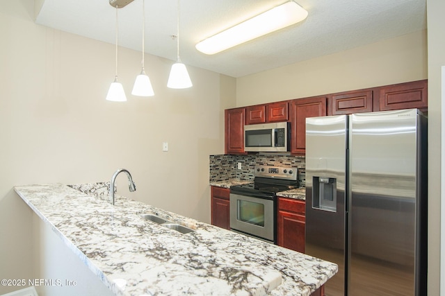 8235 Lobster Bay Ct Unit 305, Jacksonville, FL 32256 - kitchen with a sink, a peninsula, reddish brown cabinets, stainless steel appliances, and backsplash