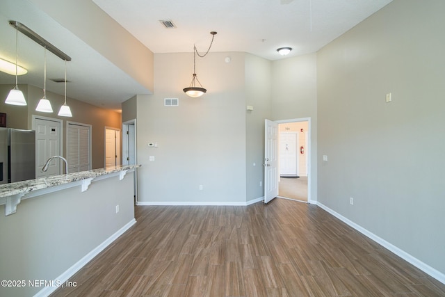 8235 Lobster Bay Ct Unit 305, Jacksonville, FL 32256 - unfurnished living room with dark wood-type flooring, visible vents, baseboards, and a high ceiling