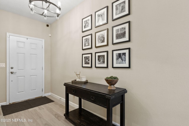 75743 Spoonbill Ln, Yulee, FL 32097 - foyer entrance featuring a chandelier, baseboards, and light wood-style flooring
