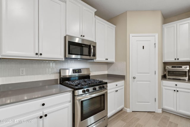 75743 Spoonbill Ln, Yulee, FL 32097 - kitchen with stainless steel appliances, tasteful backsplash, white cabinets, and light wood-type flooring