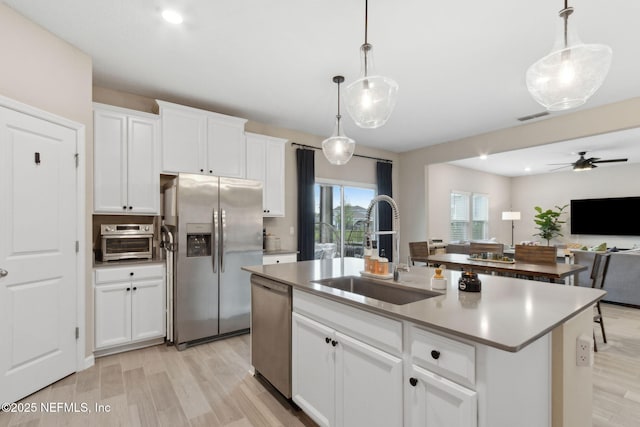 75743 Spoonbill Ln, Yulee, FL 32097 - kitchen with visible vents, appliances with stainless steel finishes, a sink, open floor plan, and light wood finished floors