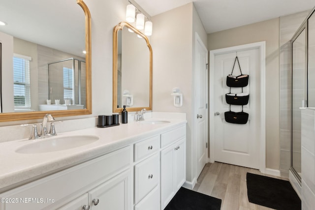 75743 Spoonbill Ln, Yulee, FL 32097 - full bathroom featuring a sink, a shower stall, double vanity, and wood finished floors