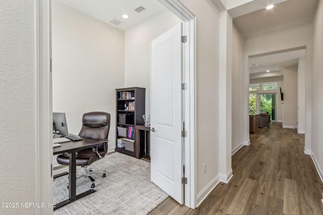 office area with wood finished floors, baseboards, and visible vents