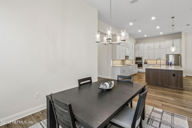 dining space with visible vents, baseboards, a chandelier, recessed lighting, and wood finished floors