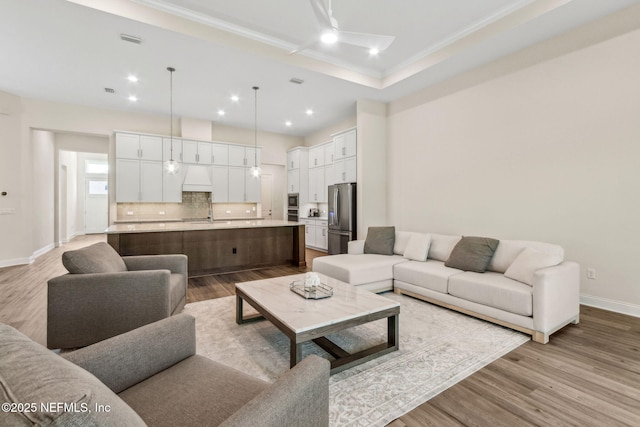 living area featuring recessed lighting, light wood-style floors, baseboards, and visible vents