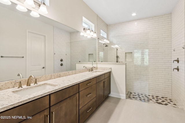 full bath with a walk in shower, double vanity, and a sink