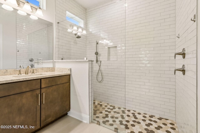 bathroom with tiled shower and vanity