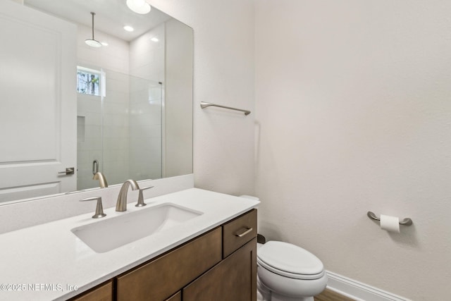 full bathroom featuring toilet, a shower stall, vanity, and baseboards