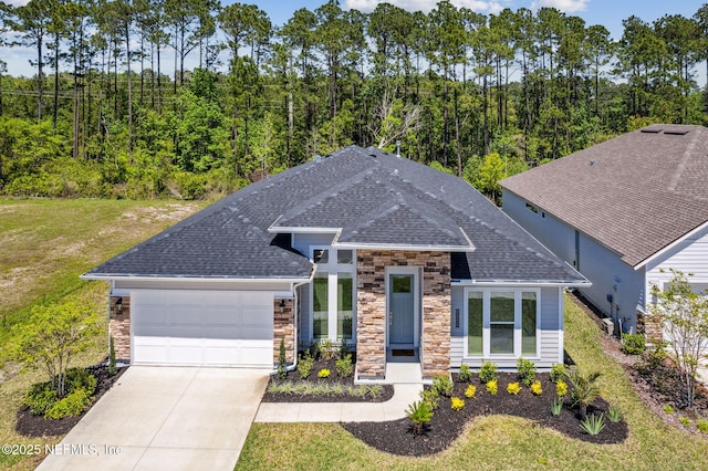 view of front of property featuring driveway, stone siding, an attached garage, a front yard, and a shingled roof