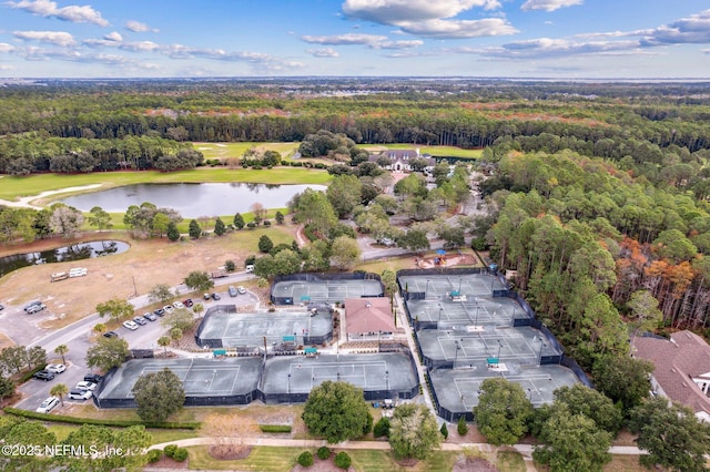 drone / aerial view featuring a view of trees, golf course view, and a water view