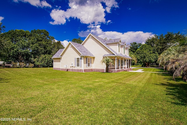 rear view of property with a yard and a shingled roof