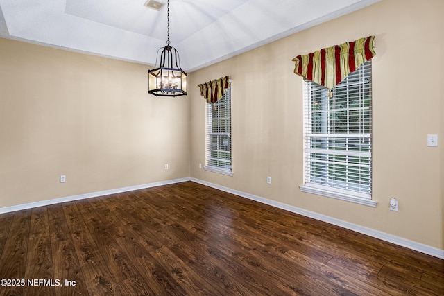 unfurnished room with a chandelier, a wealth of natural light, baseboards, and dark wood finished floors