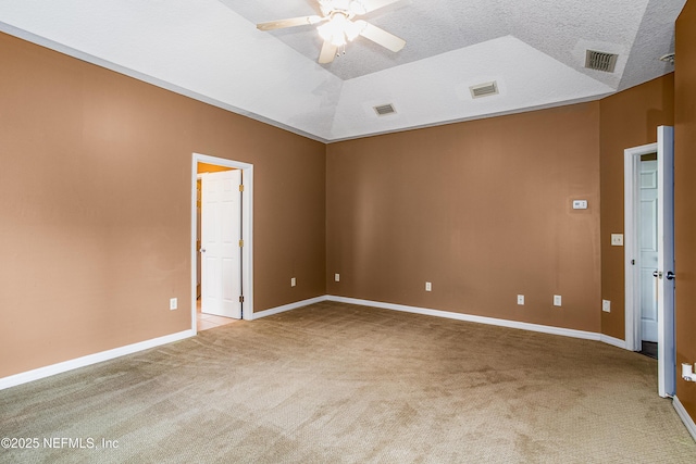 spare room featuring visible vents, a ceiling fan, vaulted ceiling, and light carpet