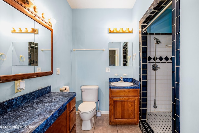 full bathroom featuring toilet, tile patterned floors, tiled shower, and vanity