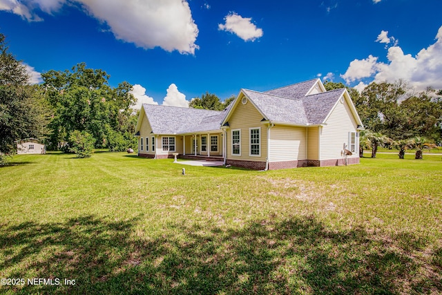 rear view of property with a yard and a patio area