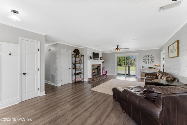 12531 County Road 121, Bryceville, FL 32009 - living room with ceiling fan, ornamental molding, visible vents, wood finished floors, and a brick fireplace