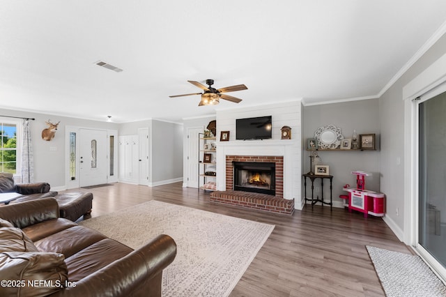 12531 County Road 121, Bryceville, FL 32009 - living room with crown molding, a brick fireplace, visible vents, ceiling fan, and wood finished floors