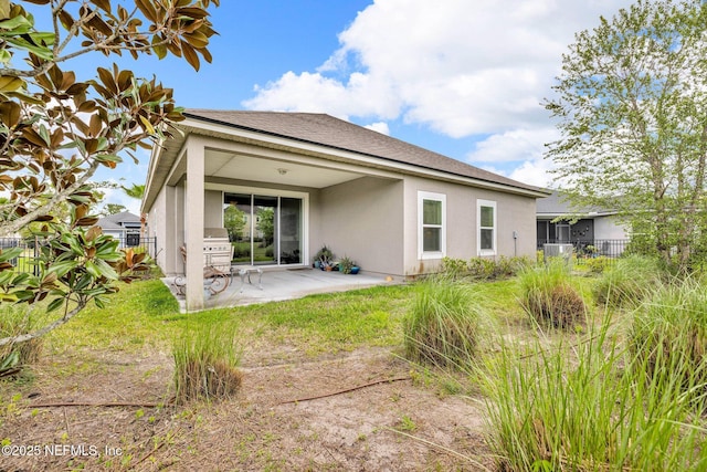 back of house featuring a patio, fence, roof with shingles, and stucco siding