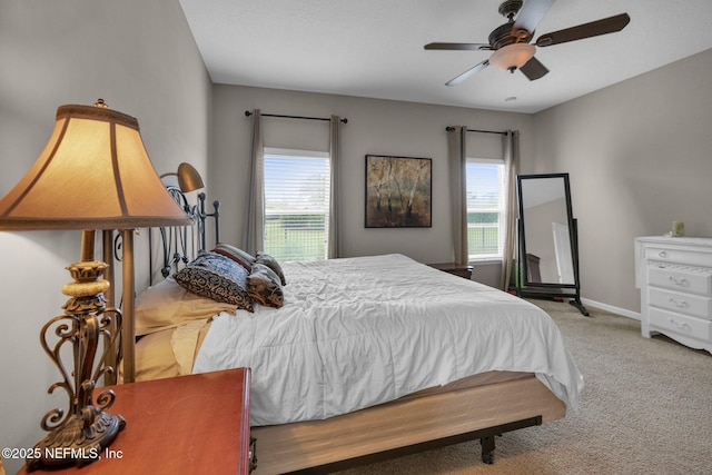bedroom with carpet floors, a ceiling fan, baseboards, and multiple windows